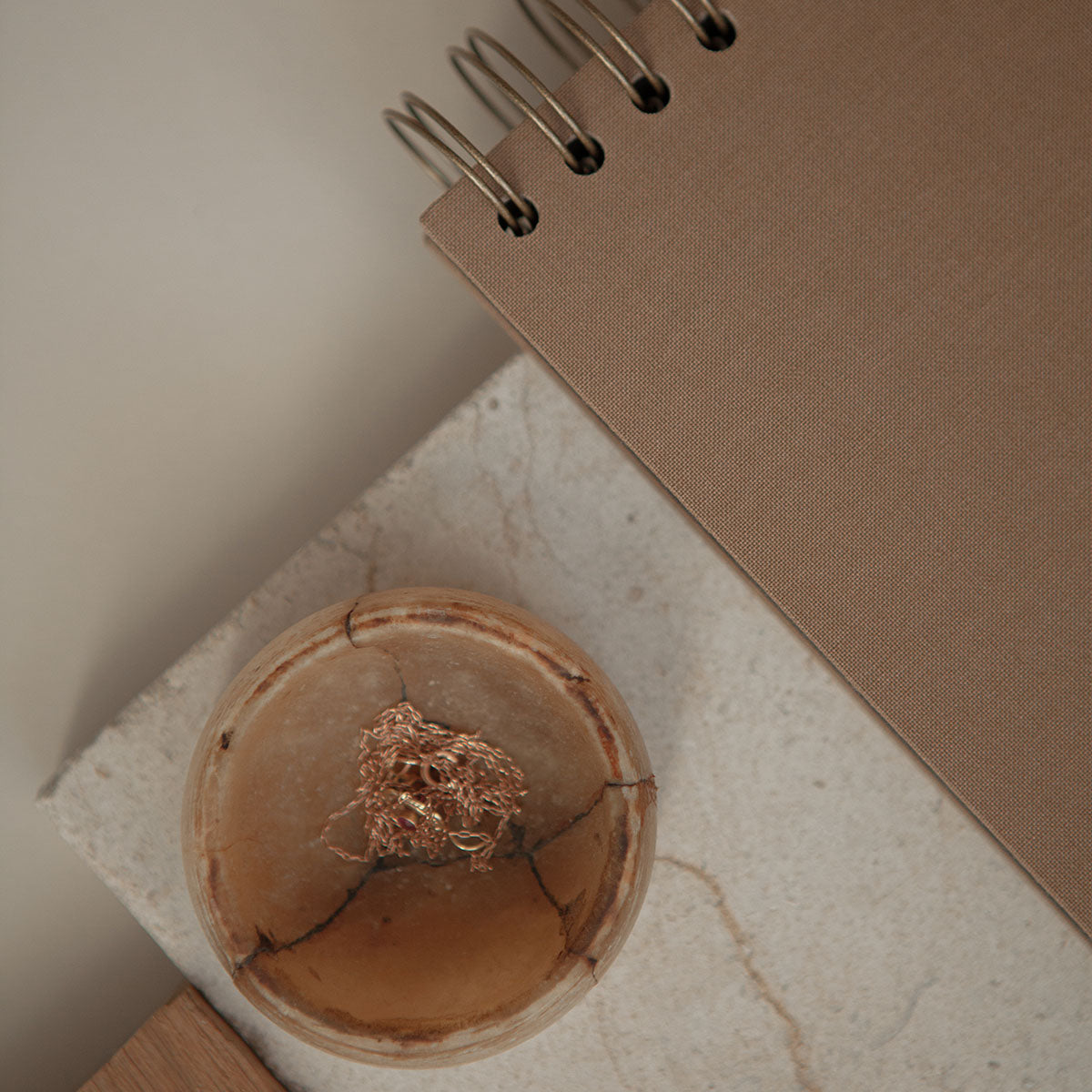 Fragment brązowego albumu na zdjęcia na spirali w kolorze miedzianym.