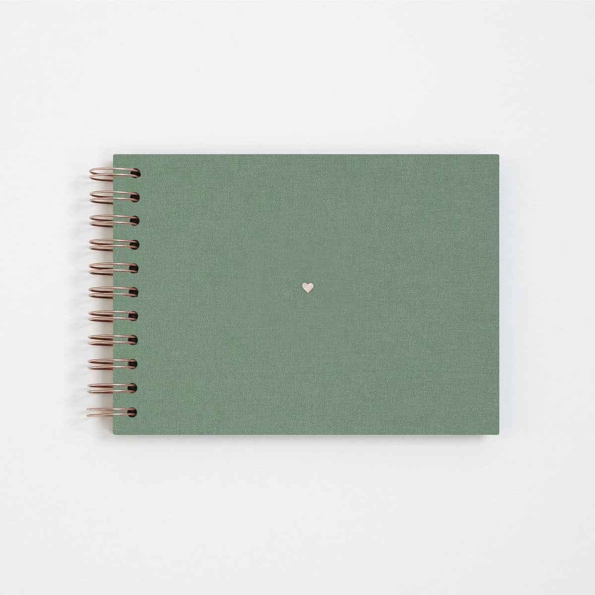 Płócienny album na zdjęcia w kolorze zielonym. Wykończony miedzianą spiralą oraz małym serduszkiem w centrum.